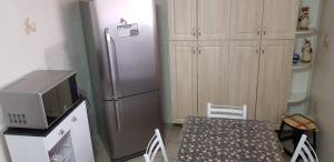 a small kitchen with a table and a refrigerator at Apto Pé na Areia Santos in Santos