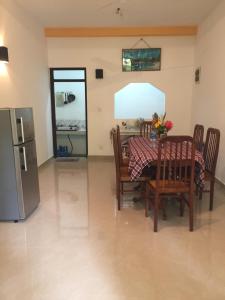 a kitchen and dining room with a table and a refrigerator at Ramya Villa in Unawatuna