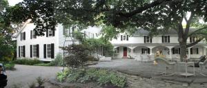 a large white house with chairs and a patio at Niagara Mansion Carriage Suite in Lewiston