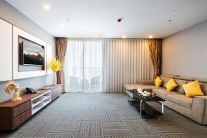 Una sala de estar con un sofá y un televisor. en LeMore Hotel Nha Trang, en Nha Trang