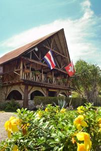 ein Haus mit zwei Flaggen davor in der Unterkunft Hotel Suizo Loco Lodge & Resort in Cahuita