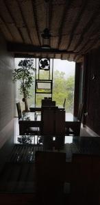 a dining room with a table and chairs and a large window at Rajarata Reach Resort in Anuradhapura