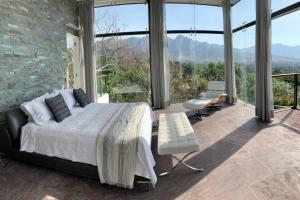 a bedroom with a bed and large glass windows at Casa de las Aves - Alberca y Jacuzzi climatizados - Espectaculares vistas in Malinalco