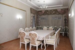 a dining room with a white table and chairs at Sary Arka Hotel in Shymkent