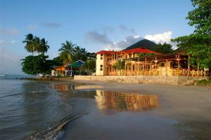 a building on the beach next to the water at Cabañas y Restaurante Miss Elma in Providencia