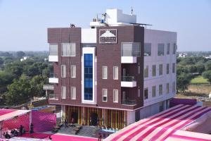 斋浦尔Hotel Le Grande的一座挂着招牌的高砖建筑