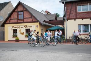 un gruppo di persone in bicicletta di fronte a un edificio di Gasthof zum Slawen a Vetschau