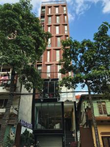 ein hohes rotes Gebäude mit einem Baum davor in der Unterkunft Max Boutique Hotel in Cao Bằng