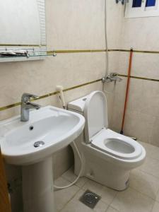 a bathroom with a white toilet and a sink at Lana Jeddah Furnished Apartments in Jeddah