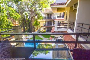 a view of a pool from the balcony of a building at Woodside Retreat- Serviced Apartments in Baga