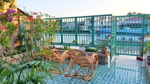 a patio with chairs and a table with plants at Tien Yoga House in Cái Bè