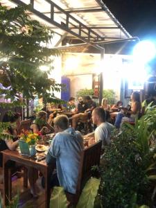 a group of people sitting at tables in a restaurant at Hotel4U Koh Tao in Ko Tao