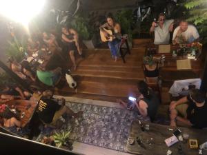 a group of people sitting on the stairs with a man playing guitar at Hotel4U Koh Tao in Ko Tao