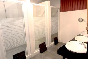 a bathroom with two sinks and a shower at Hostels Meetingpoint in Madrid