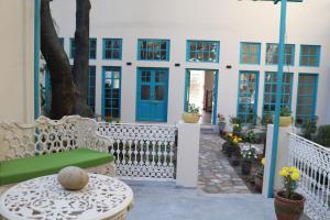 a patio with a bench and a blue door at Mango Tree Courtyard Dehradun in Dehradun