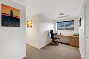 un bureau avec un bureau et une chaise dans la chambre dans l'établissement Fairway Village @ Windaroo Lakes Golf Club, à Windaroo