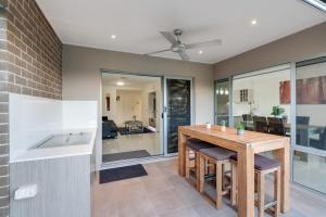 a kitchen and dining room with a wooden table and chairs at Fairway Village @ Windaroo Lakes Golf Club in Windaroo