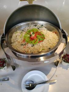 a pot of rice on a table with a plate at Zodiak Kebon Kawung by KAGUM Hotels in Bandung