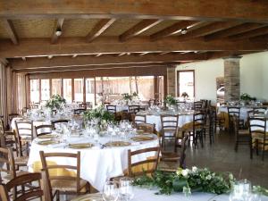 a banquet hall with tables and chairs with white tablecloths at Hotel Corsaro Nero in Portu Maga
