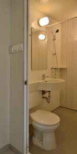 a bathroom with a white toilet and a sink at Zodiak Kebon Kawung by KAGUM Hotels in Bandung
