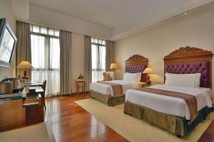 a large hotel room with two beds and a television at Royale Chulan Kuala Lumpur in Kuala Lumpur