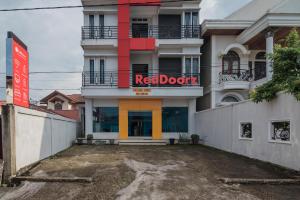 a building with a red door sign on it at RedDoorz Syariah near Jamtos Jambi in Jambi