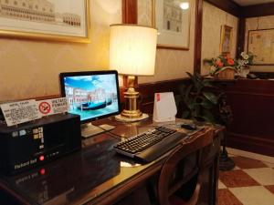a desk with a computer and a lamp on it at Hotel Falier in Venice