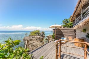 a wooden deck with a view of the ocean at Le Cliff Bali in Uluwatu