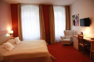 una camera d'albergo con un grande letto e una scrivania di Pension Dvořák a Karlovy Vary