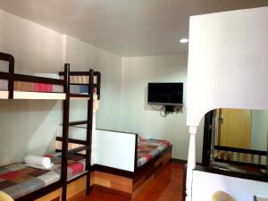 a room with two bunk beds and a flat screen tv at Park Vil-la Apartelle in Manila