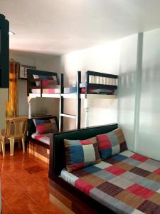 a room with two bunk beds and a couch at Park Vil-la Apartelle in Manila