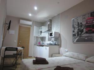 een kleine kamer met een bed en een keuken bij Apartamentos Adressadors in Valencia