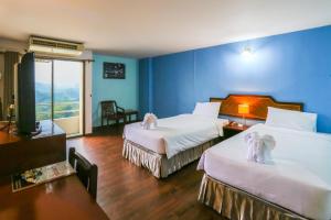 Säng eller sängar i ett rum på Wiangwalee Hotel