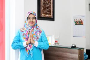 a woman standing in a room wearing a scarf at Polamas Residence Padang in Padang