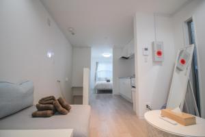 a white living room with a couch and a table at CASA Higashi Mikuni 02 in Osaka