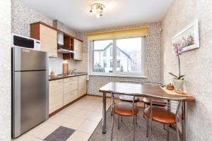 cocina con mesa y nevera en Apartamentai Pluke, en Palanga