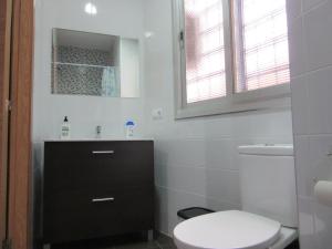 een witte badkamer met een toilet en een wastafel bij Apartamentos Adressadors in Valencia