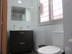 Baño blanco con aseo y lavamanos en Apartamentos Adressadors, en Valencia
