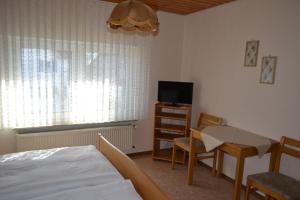 a bedroom with a bed and a desk and a television at Landgasthaus Krone in St. Johann in Sankt Johann