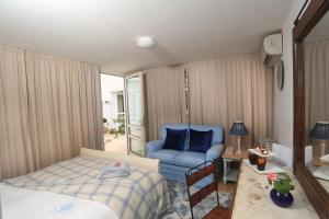 a bedroom with a bed and a blue chair at Sunny Garden Studio in Nicosia