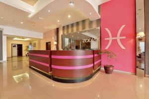 a lobby of a hotel with a pink wall at Zodiak Kebon Kawung by KAGUM Hotels in Bandung