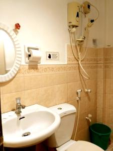 uma casa de banho com um WC, um lavatório e um chuveiro em Sola Eleganza Apartelle em Manila