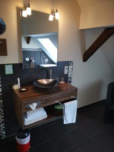 ein Bad mit einem Waschbecken und einem Spiegel in der Unterkunft Hotel Stadt Steinheim in Steinheim
