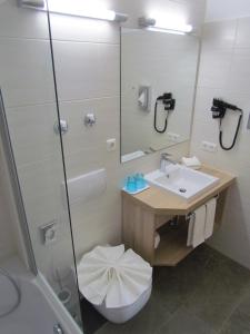 a bathroom with a toilet and a sink and a shower at Hotel AMENITY in Munich