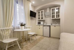 a small kitchen with a small table and a sink at Apart Hotel Quartet in Odesa