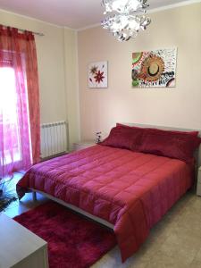a bedroom with a large bed with a red blanket at A Casa di Siria in Gela