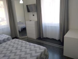 a bedroom with a bed and a dresser and a mirror at B&B Gaslini & Mare (anche con uso cucina) in Genoa
