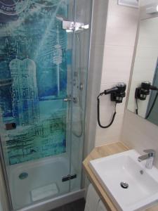 uma casa de banho com um chuveiro e um lavatório. em Hotel AMENITY em Munique