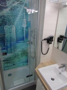 a bathroom with a shower and a sink at Hotel AMENITY in Munich