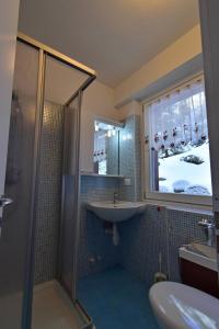 ein Bad mit einer Dusche, einem Waschbecken und einem Spiegel in der Unterkunft MIRADOLO in Madonna di Campiglio
